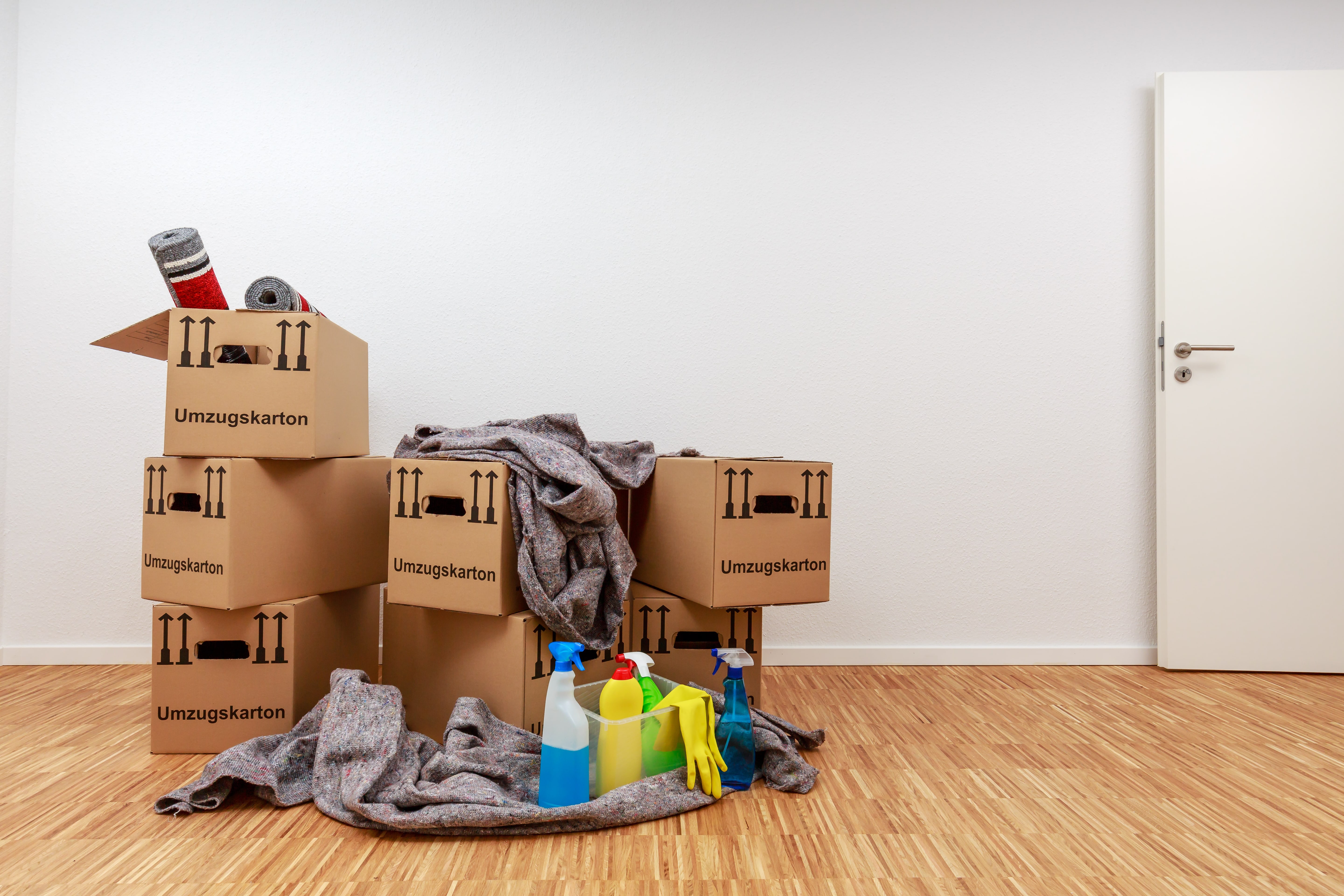 Umzugskartone mit Reinigungsmittel in einer neuen Wohnung